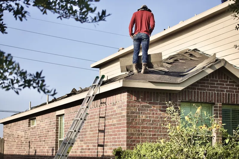 Professional roofer working on a residential roof in Monroe Manor